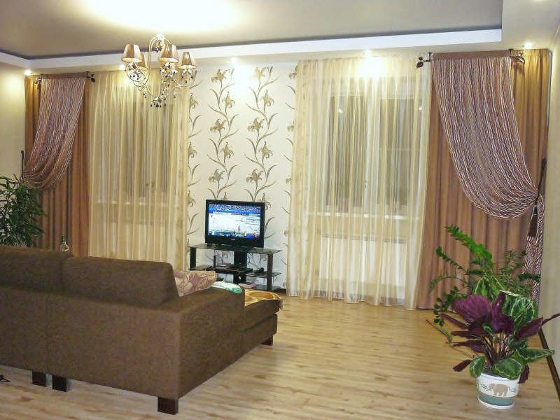 Телевизор между двумя окнами фото в гостиной и шторы